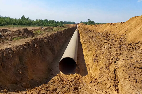 Laying pipelines in ditch with the help of pipelayer loaders, construction of oil pipelines and gas pipelines in remote areas.