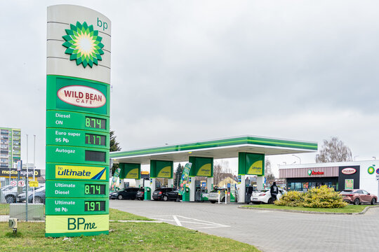 ZABRZE, POLAND - MARCH 29, 2026: BP gas station exterior with a large green price pylon featuring the Wild Bean Cafe logo. Cars are seen refueling under the canopy on a cloudy day.