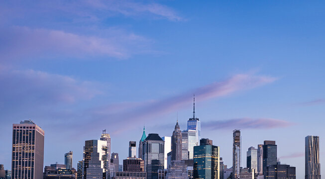 New York City skyline at dusk featuring One World Trade Center and Lower Manhattan