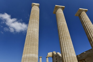 Lindos Acropolis, Lindos, Rhodes Island, Greece. The tall column and cornice of an archeological Roman-Greek temple site of Athena from the 4th century BC in Spring. © alagz