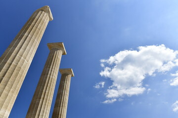Lindos Acropolis, Lindos, Rhodes Island, Greece. The tall column and cornice of an archeological Roman-Greek temple site of Athena from the 4th century BC in Spring. © alagz