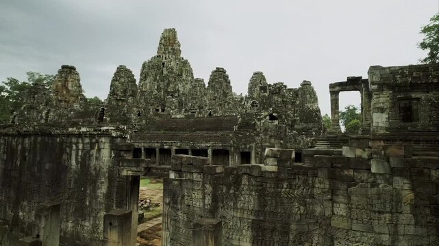 Ancient bas reliefs and carved stone faces on the walls of the Bayon temple in Cambodia