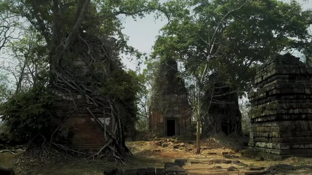 Stone ruins of the ancient Prasat Pram temple being reclaimed by strangler fig tree roots in Cambodia
