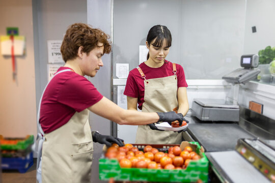 Grocery store assistants sorting fresh produce efficiently