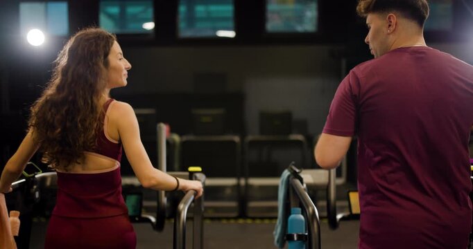 Friends work out together at fitness center using exercise machines in a group setting without any distractions