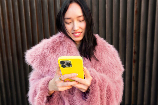 Young woman embraces urban lifestyle with smartphone