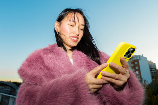 Urban lifestyle portrait of a Gen Z woman with smartphone
