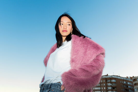 Asian woman in urban setting embracing modern style