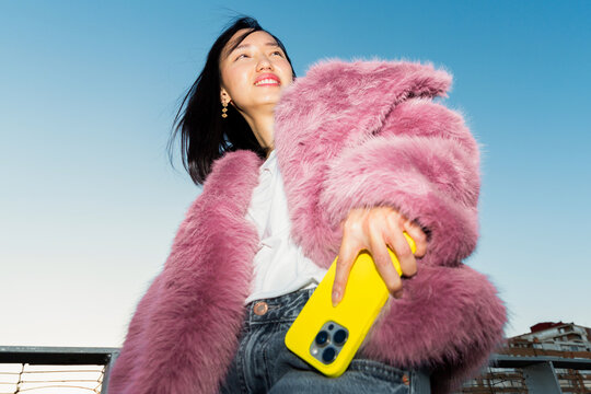 Gen Z asian woman enjoying vibrant urban lifestyle