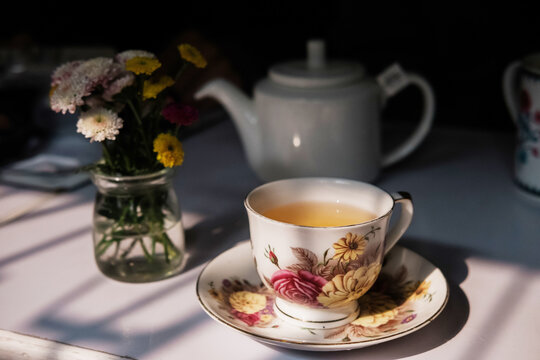 Elegant tea moment with floral teacup in natural light