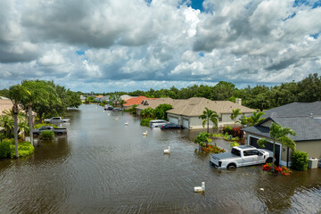Obraz premium Flooded houses and cars from hurricane Debby rainfall water in Laurel Meadows community in Sarasota, Florida. Aftermath of natural disaster in USA south