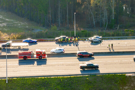 Severe car accident on American freeway. Emergency services helping victims of vehicle crash on highway road in USA.