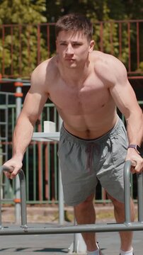 Athletic caucasian topless muscular man doing push-up exercise on playground. Young shirtless bodybuilder boy. Sports, health care, fitness routine cardio, workout. Strength, motivation. Outdoors gym