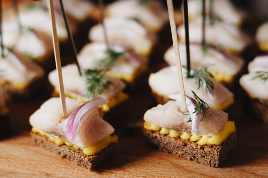 An array of elegant fish canapes with mustard and dill on rye bread, perfect for catering or gourmet events.