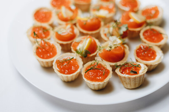 Exquisite canapes with salmon roe and dill adorn a white plate, perfect for gourmet events and culinary presentations.