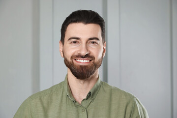 Fototapeta premium Portrait of handsome man near white wall indoors