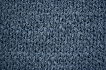 Fototapeta premium macro texture of blue knitted fabric with detailed pattern. Close-up of soft textile showing woven structure and calm cool tones. Clean and modern background perfect for winter concepts, fashion, tech