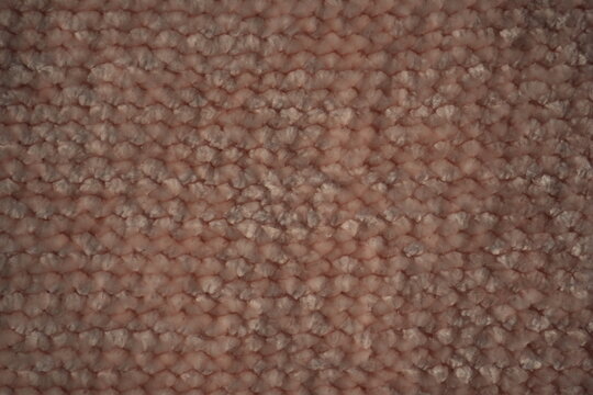 macro texture of soft pink plush fabric. Close-up of cozy textile with delicate fibers and warm pastel tones. Smooth, soft surface creates a calm and comfortable background perfect for fashion, home d