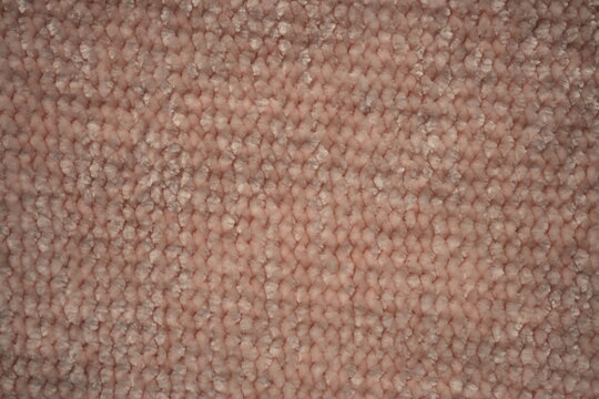macro texture of soft pink plush fabric. Close-up of cozy textile with delicate fibers and warm pastel tones. Smooth, soft surface creates a calm and comfortable background perfect for fashion, home d
