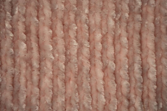 macro texture of soft pink plush fabric. Close-up of cozy textile with delicate fibers and warm pastel tones. Smooth, soft surface creates a calm and comfortable background perfect for fashion, home d