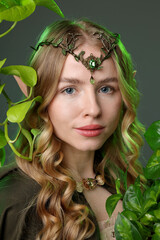 Obraz premium Beautiful elf girl and green leaves on grey background