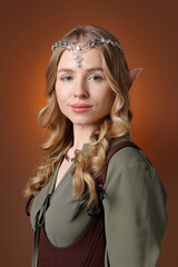 Obraz premium Beautiful girl dressed as elf on brown gradient background