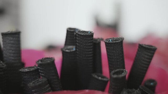 Detailed view of black coiled cable insulation organized in production processes within an industrial setting