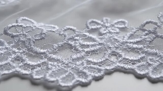 Close-up of elegant white lace fabric with intricate floral embroidery. Ideal for bridal, fashion, and textile design projects, adding beauty, luxury, and romantic charm to garments and decor.