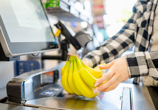 Girl At Self-Checkout Is Weighing Items