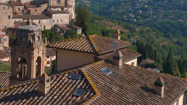 Medieval rooftops and bell tower in an italian hilltop town. Aerial view of urbino's historic center with its traditional terracotta tile roofs, ancient stone buildings, and a classic bell tower