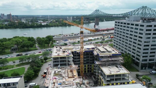 4K aerial drone flying past construction crane toward Jacques Cartier Bridge in Montreal