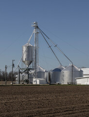Obraz premium Grain bins on a farm in the Midwest. Grain bins can be used to store wheat, corn, oats, soybeans, sunflower seeds and barley.