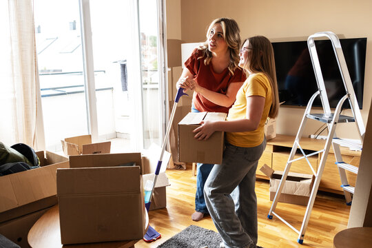 A mother and her kids are unpacking boxes and moving into their new home.