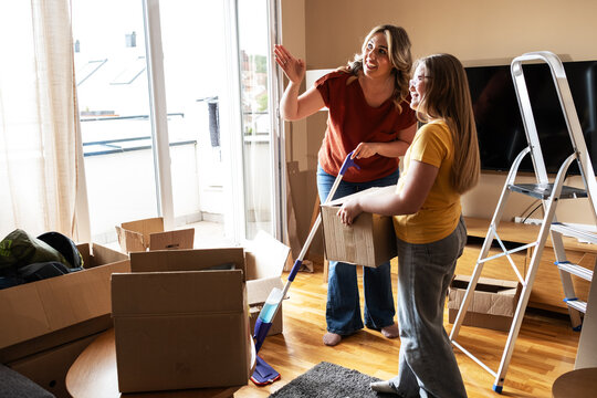 A mother and her kids are unpacking boxes and moving into their new home.