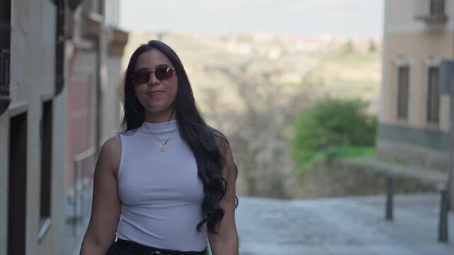 Latina woman walking on city street nodding head saying yes