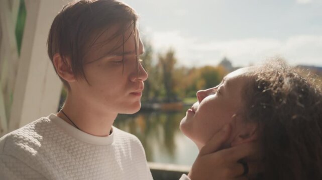 Intimate closeup white man black woman kissing with gentle caress, wet hair, sunlight glinting on lake, tight framing on faces, emotional exchange after kiss, flirtatious smile, romantic chemistry,