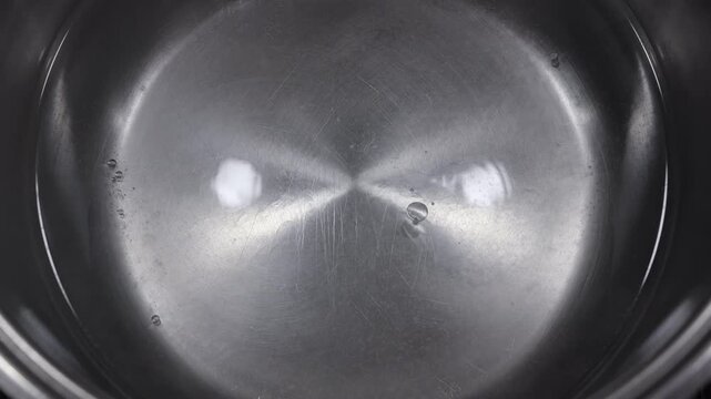 Boiling water in a stainless steel pot in slow motion