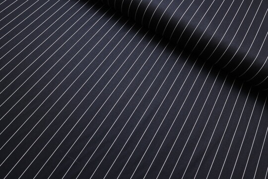 High-quality pinstripe fabric texture background. Elegant dark navy wool cashmere textile with subtle vertical stripes, perfect for luxury suit tailoring, fashion design, and business apparel.