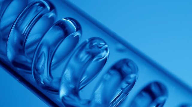 Blue liquid chemicals moving through glass spiral in lab on neon background.