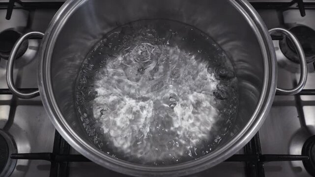 Boiling water in a stainless steel pot in slow motion