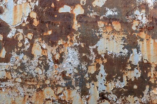 Rusty surface with peeling paint in urban area
