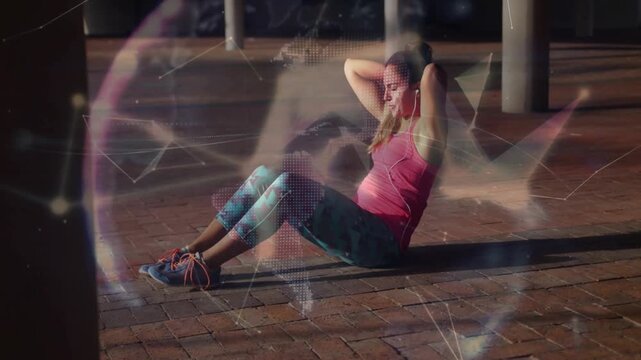 Woman tucking feet under curb and crunching while polygons forming globe grid tracking fitness data