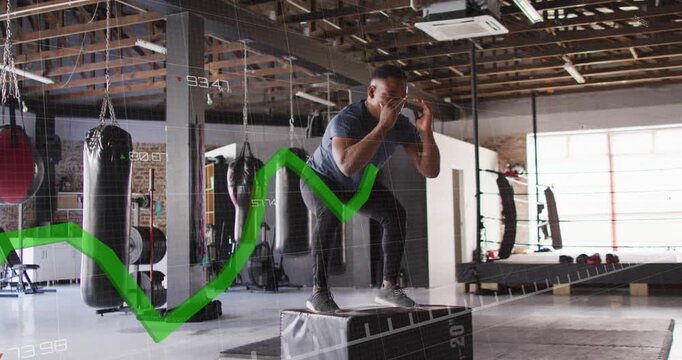 Man nearing plyo box at gym swinging arms jumping landing bracing training tracking green overlay