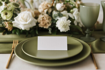Obraz premium Blank place card on elegant table setting with green plates and floral arrangement