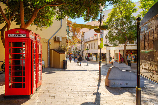 The entrance into Main Street, the central shopping and dining street through the historic old town, with an iconic red K6 kiosk telephone box in Gibraltar, a British Territory on the south of Spain.