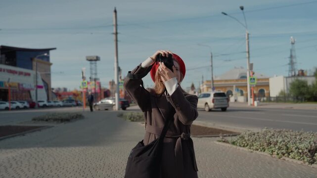 Young woman composing city skyline shot, sidewalk vantage, beret backlit by sun, scanning horizon and framing architecture, mirrorless camera held steady, tranquil autumn mood, long hair flowing,