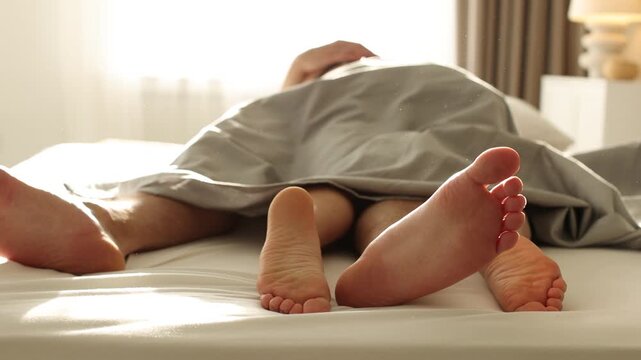 Lovely couple having sex in bed at home, closeup. Camera moving forward and backwards