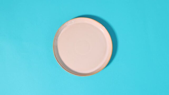 Man changing plates on light blue background, top view