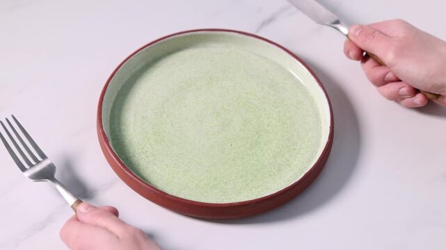 Woman with cutlery and plate at white table, closeup