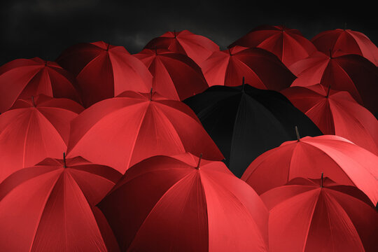 Red umbrellas together with one black umbrella, background